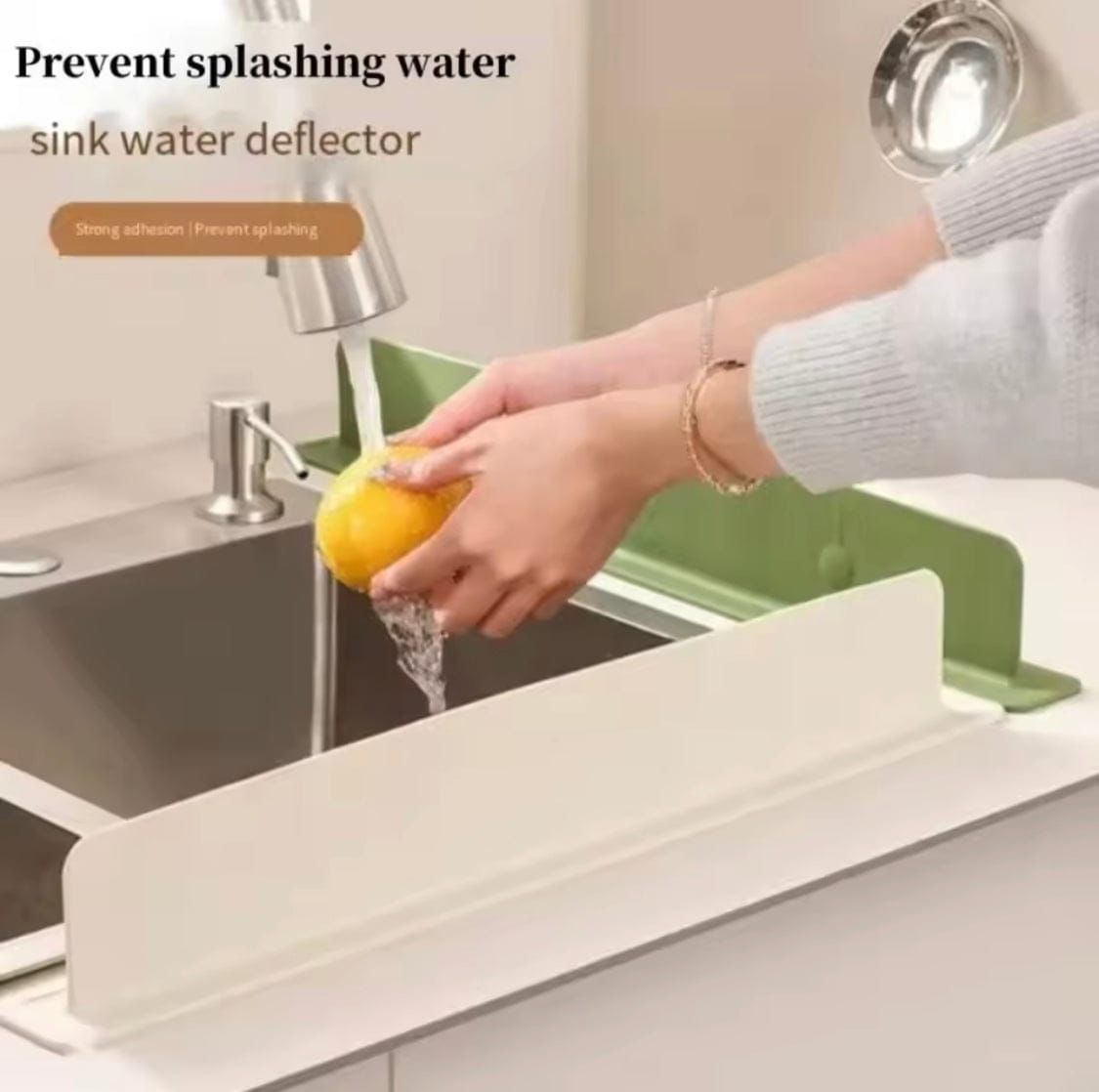 Person washing a lemon over a sink water deflector with text 'Prevent splashing water' and 'sink water deflector'.